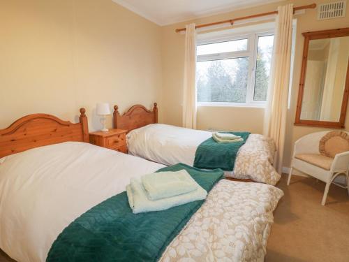 1 dormitorio con 2 camas, silla y ventana en Cheriton en Tuxford