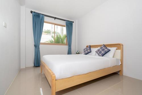 una camera da letto con un letto con tende blu e una finestra di Brand New 2BR House in Yamu Garden A1 a Ban Bang La