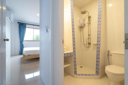 ein Bad mit einem WC und einer Dusche mit einem Spiegel in der Unterkunft Brand New 2BR House in Yamu Garden A1 in Ban Bang La