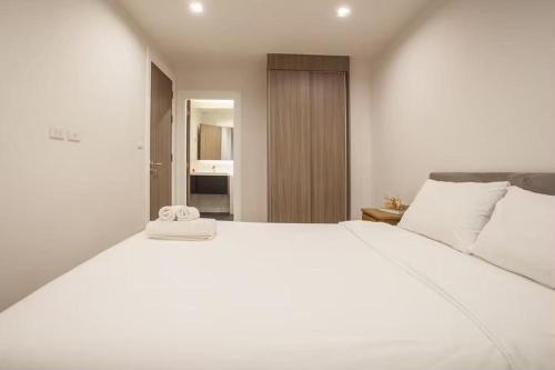 białe łóżko z ręcznikiem na górze w obiekcie Bangsaray vacation 1 w mieście Bang Sare