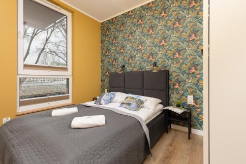 una camera da letto con un letto e carta da parati floreale di Active City Apartments Warsaw by Renters a Varsavia