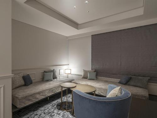 a living room with a couch and a table and chairs at GINZA HOTEL by GRANBELL in Tokyo