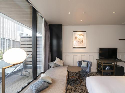 a hotel room with a bed and a balcony at GINZA HOTEL by GRANBELL in Tokyo