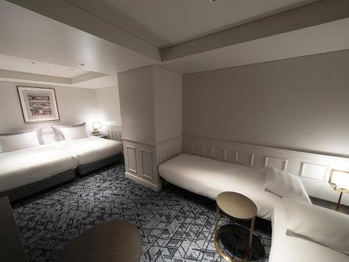 a hotel room with two beds and a table at GINZA HOTEL by GRANBELL in Tokyo