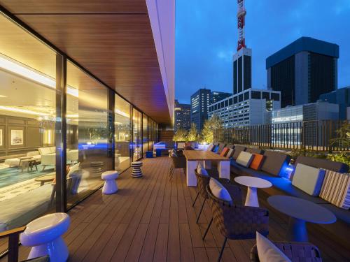 a balcony with tables and chairs and a city skyline at GINZA HOTEL by GRANBELL in Tokyo
