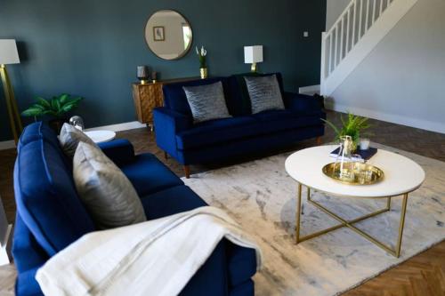 a living room with a blue couch and a table at The Coach House at Wenvoe Manor, Cardiff in Wenvoe