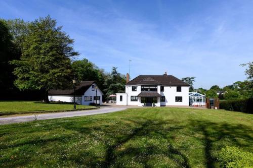 duży biały dom na trawiastym polu w obiekcie The Coach House at Wenvoe Manor, Cardiff w mieście Wenvoe