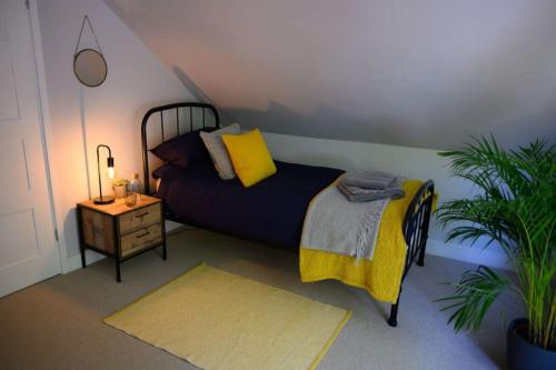 a bedroom with a bed and a night stand with a lamp at The Coach House at Wenvoe Manor, Cardiff in Wenvoe