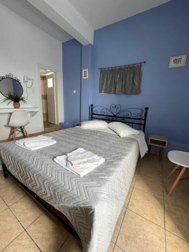 a bedroom with a large bed with blue walls at Stella Nomikou Apartments in Firostefani