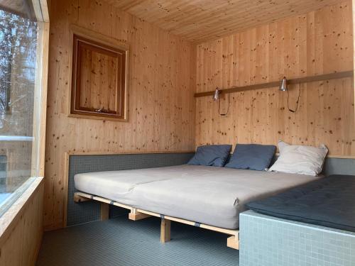um quarto com uma cama num quarto de madeira em Gut Hornegg em Preding