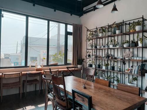uma sala de jantar com mesa, cadeiras e janelas em Lugo Hotel em Manzhou