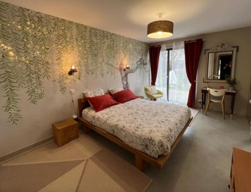 ein Schlafzimmer mit einem Bett mit roten Kissen in der Unterkunft Relais de La Brande in Saint-Gourson