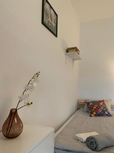 a bedroom with a bed and a vase with flowers on a table at Noclegi Little Sheep in Chojna