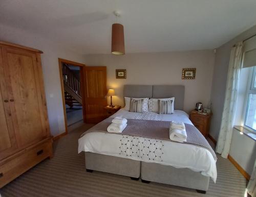 a bedroom with a large bed with towels on it at Inishmore Island B&B in Inishmore
