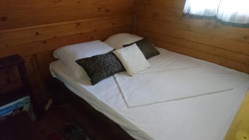 a bed with four pillows on it in a room at Apartmani Dada Kanjon Grmuša in Bihać