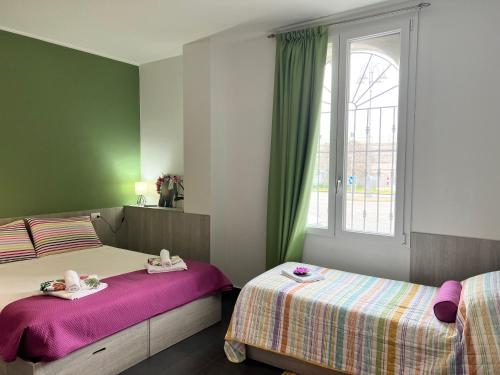 a bedroom with two beds and a window at Bnbook Residence Matteotti in Novara