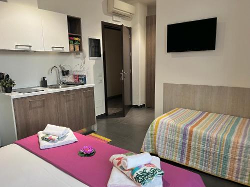 a room with a kitchen with a bed and a sink at Bnbook Residence Matteotti in Novara