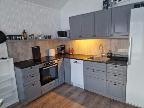 una cocina con armarios grises y fregadero en Cottage - two bedrooms, en Blönduós