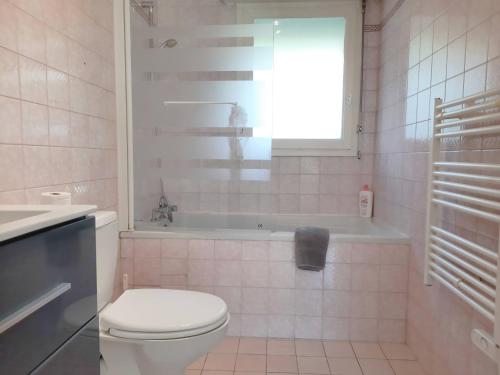 a bathroom with a toilet and a tub and a sink at Ty Cocoon- Appartement avec terrasse et parking privé in Quimper
