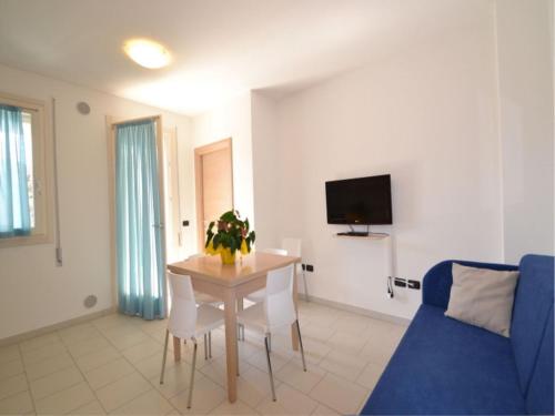 een woonkamer met een tafel en een blauwe bank bij Modern flat in central location in Rosolina Mare in Rosolina Mare
