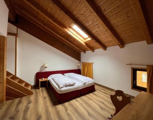 a bedroom with a bed and a wooden floor at Antico Albergo Stella d'Italia in Folgaria