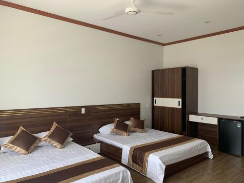a hotel room with two beds and a television at Khách sạn Ánh Trăng in Lạng Sơn