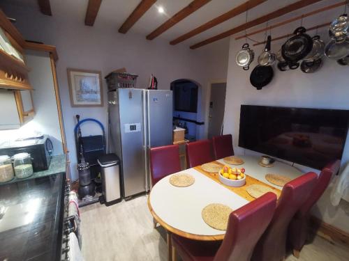 uma cozinha com uma mesa com cadeiras e um frigorífico em Tranquillity em Southbourne