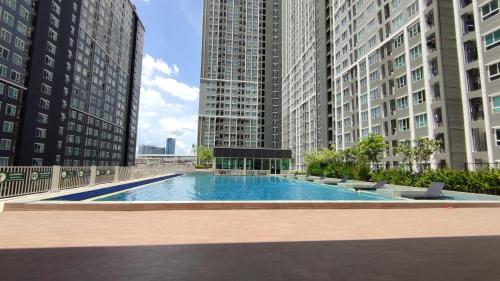 a large swimming pool in a city with tall buildings at Cozy 1-bedroom condo close to MRT near JJ market in Bang Su