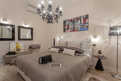 a bedroom with a large bed and a chandelier at St. George's Vatican Suites in Rome