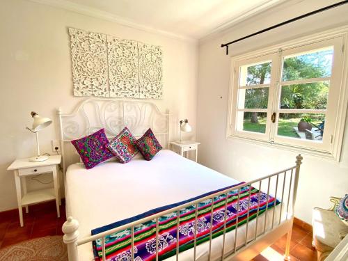 a bedroom with a white bed with colorful pillows at Thai Garden Villa in Palma de Mallorca