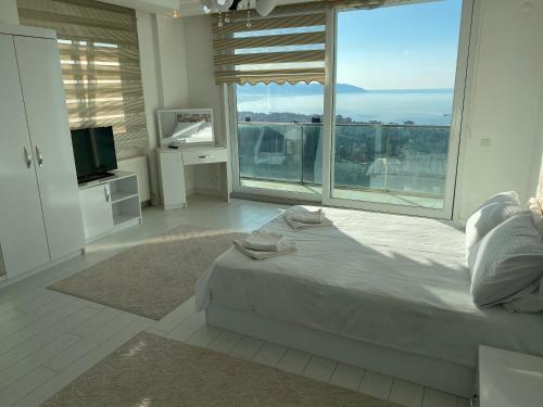 a bedroom with a bed and a large window at TRABZON PANORAMA APART in Trabzon