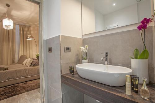 uma casa de banho com um lavatório branco e um quarto em St. George's Vatican Suites em Roma