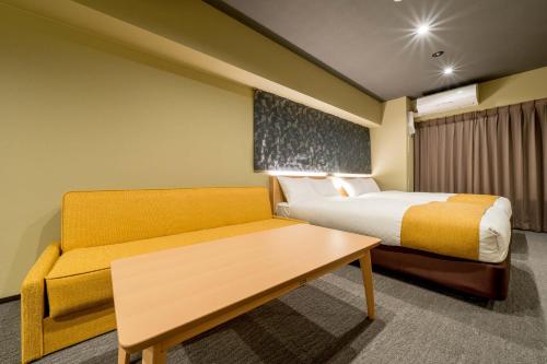 een hotelkamer met een bed en een bank bij RESI STAY ANDON in Kyoto