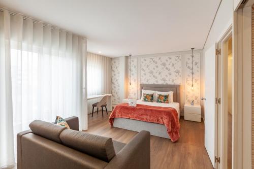 a bedroom with a bed and a couch at Flamingo Apartment in City Center - Minho's Guest in Braga