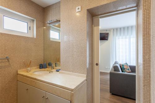 a bathroom with a sink and a mirror at Flamingo Apartment in City Center - Minho's Guest in Braga