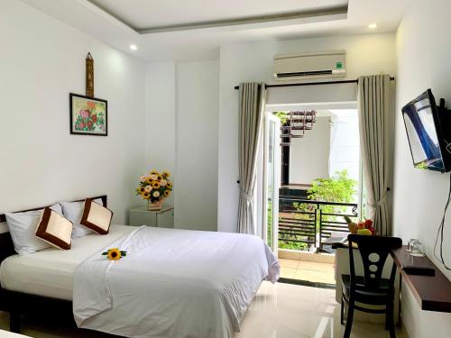 una camera con letto, scrivania e finestra di Ngọc Sinh Homestay a Hoi An