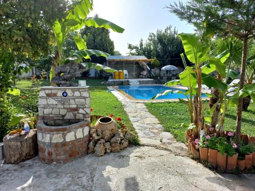 un patio trasero con piscina y una fuente de piedra en Farm House in Kusadasi en Aydın