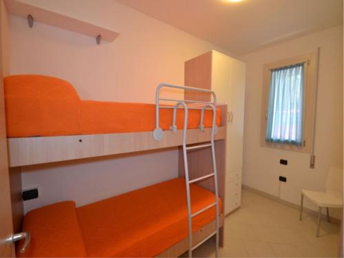 um quarto com 2 beliches e uma escada em Modern flat with private garden in Rosolina Mare em Rosolina Mare