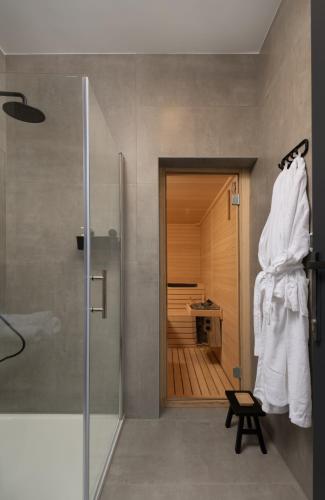 a bathroom with a walk in shower and a robe at Oak House in Brušane