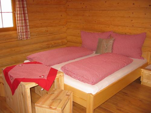 um quarto com duas camas num chalé de madeira em Tomperkasa em Apriach