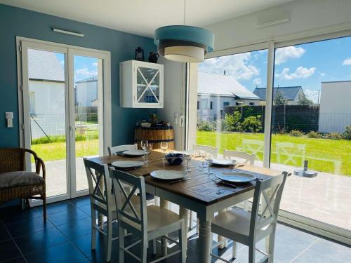 une salle à manger avec une table et des chaises en bois dans l'établissement Maison 3 étoiles jardin parking, plage 100m - FR-1-542-19, à Pleumeur-Bodou