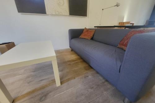 ein Wohnzimmer mit einem blauen Sofa und einem weißen Tisch in der Unterkunft Comfortable studio in the historical center in Avignon