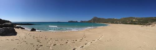 a beach with footprints in the sand and the ocean at Falassarna Beach studios&apartments in Falasarna