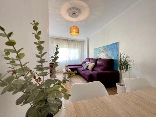 a living room with a purple couch and a table at Apartamento céntrico y cerca de la playa in Ribeira