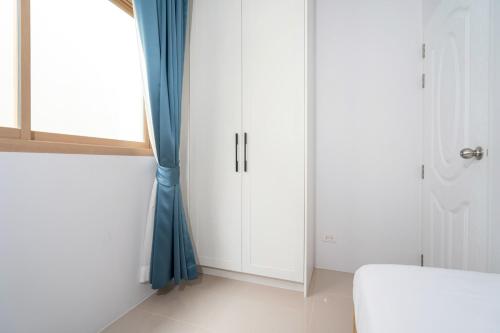 baño con armarios blancos y cortina azul en Newly Designed 3BR Fusion House in Yamu Garden B1 en Ban Bang La