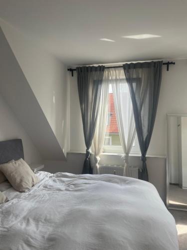 ein Schlafzimmer mit einem weißen Bett und einem Fenster in der Unterkunft Executive Maisonette Penthouse Loft, Rooftop Pool, Central Hannover and Direct Messe Connection in Hannover