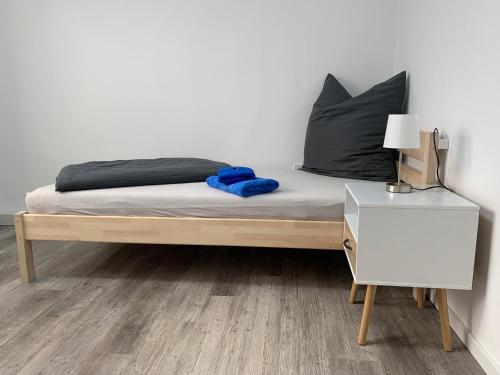 een bed met een blauwe deken en een nachtkastje bij Apartment 70 qm Kalimandscharo 3 in Zielitz - Magdeburg in Zielitz