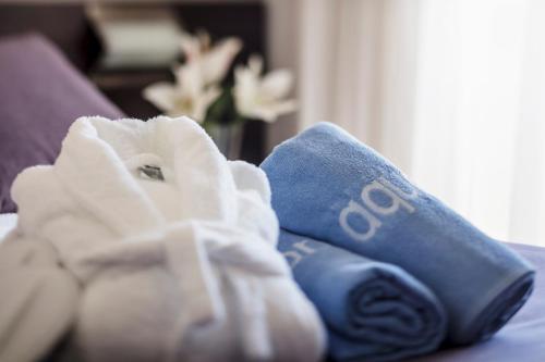 una pila de toallas sentadas encima de una cama en AQUA Hotel Montagut Suites 4*Sup, en Santa Susanna
