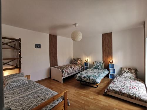 une chambre avec deux lits et un lit superposé dans l'établissement Les chambres du héron, à Chevillon