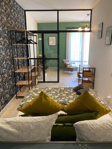 - une chambre avec un lit doté d'oreillers jaunes dans l'établissement Le Loft CITY, au cœur du village, à Saint-Rémy-de-Provence